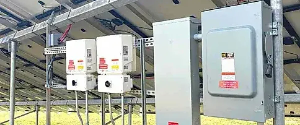 Close-up of inverter and electrical components beneath a ground mount solar panel system installed by Premier Improvements Solar in Connecticut.